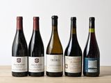 six bouteilles de vin sont alignées sur une table en bois