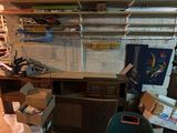 a desk and a chair in a room with a lot of clutter