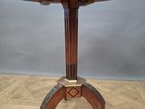 an image of a round table with a metal top on a wooden floor