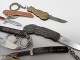 many different types of knives on a white table