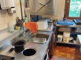 a kitchen with a sink, stove, and a stove top oven