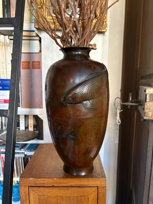 a vase with branches in it sitting on a wooden table