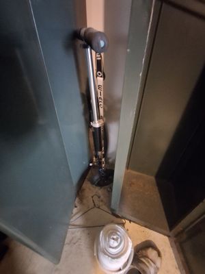 a toilet in the corner of a room with a trash can