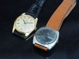 deux montres assises l'une à côté de l'autre sur une surface noire