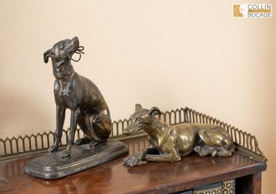 une statue en bronze représentant un chien et un chat posée sur une table