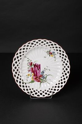 a white plate with a floral design on it on a black background