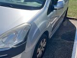 La camionnette argentée est garée sur le parking, à côté de la pelouse.