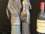 statue représentant un homme et une femme tenant une bouteille de vin