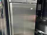 un réfrigérateur en acier inoxydable dans une cuisine, avec une étiquette bleue sur la porte