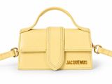 a small yellow purse with a gold logo on the front