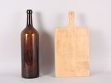 a wooden cutting board next to a bottle of wine