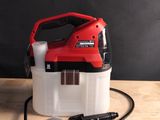 un pulvérisateur rouge et blanc posé sur une table en bois