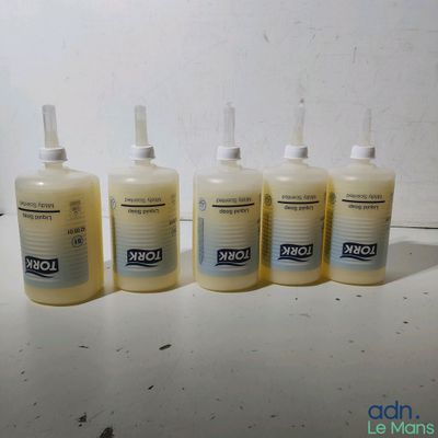 quatre flacons de gel hydroalcoolique posés sur une table