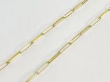 une paire de trombones plaqués or sur une surface blanche