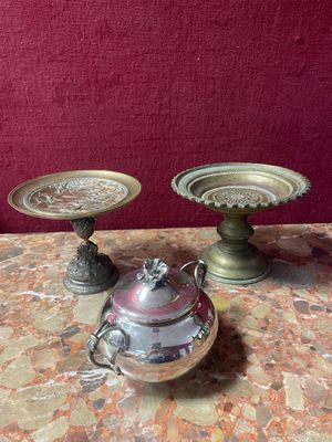 two silver vases sitting on a table with a red background