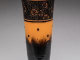 un vase noir et orange posé sur une table