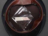 a black hat with a brown leather band and a label on it