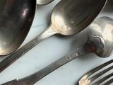 many spoons and forks on a table with silverware