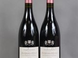 two bottles of wine sitting on top of a table next to each other