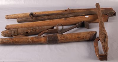 Plusieurs vieux outils en bois sont posés sur une surface blanche