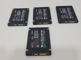four hard drives sitting on top of a white table next to each other