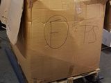 a cardboard box on a pallet with a sign on it