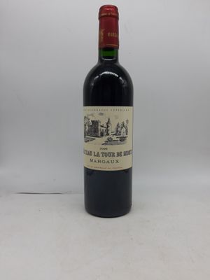 une vieille bouteille de vin posée sur une table blanche