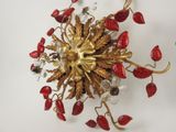 a gold and red chandelier hanging on a wall