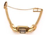 a close up of a gold bracelet with a stone on a chain