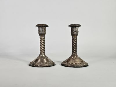 une paire de chandeliers en argent sur fond blanc