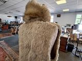 a woman in a fur coat standing in a room
