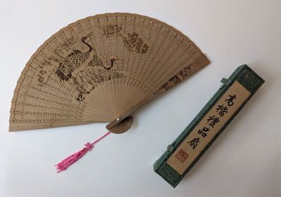 un éventail et une boîte d'encens posés sur une table