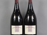deux bouteilles de vin rouge posées sur une table en verre