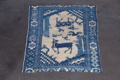 tapis en laine à décor bleu de cerfs sur fond blanc