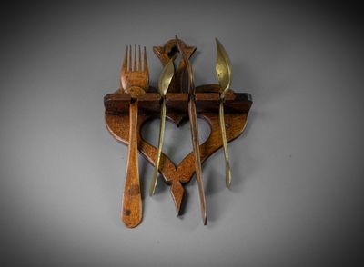 a wooden spoon and fork hanging on a wall