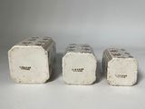 three white ceramic salt and pepper shakers sitting next to each other