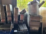 many pots and pans stacked on a table