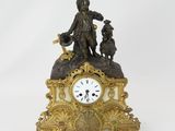 une petite horloge surmontée d'une statue