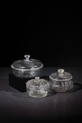 three clear glass containers sitting on top of a black surface