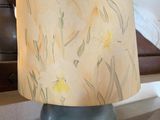 une lampe posée sur une table devant un lit