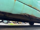 a close up of a car with rust on the side of it