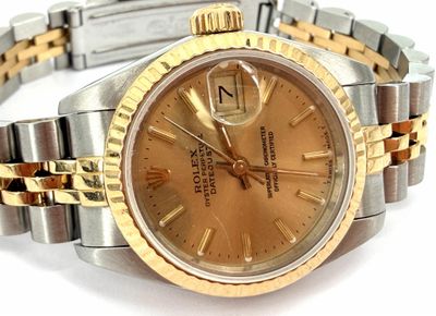 an image of a gold and silver watch on a white surface