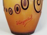 a yellow vase with black circles on it on a white surface