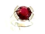 une image représentant une bague ornée d'une grosse pierre rouge entourée de diamants
