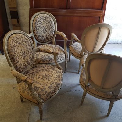 Plusieurs chaises sont alignées dans une pièce, avec une commode en arrière-plan.