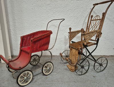 two antique baby strollers next to each other on the sidewalk