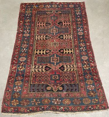 an antique persian rug with a red and blue design