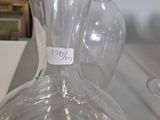 a glass vase with a label on it sitting on a table