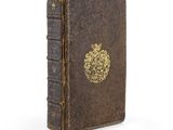 un vieux livre avec une pomme dorée sur la couverture