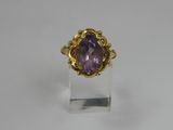 a gold ring with an amethorate stone in the center